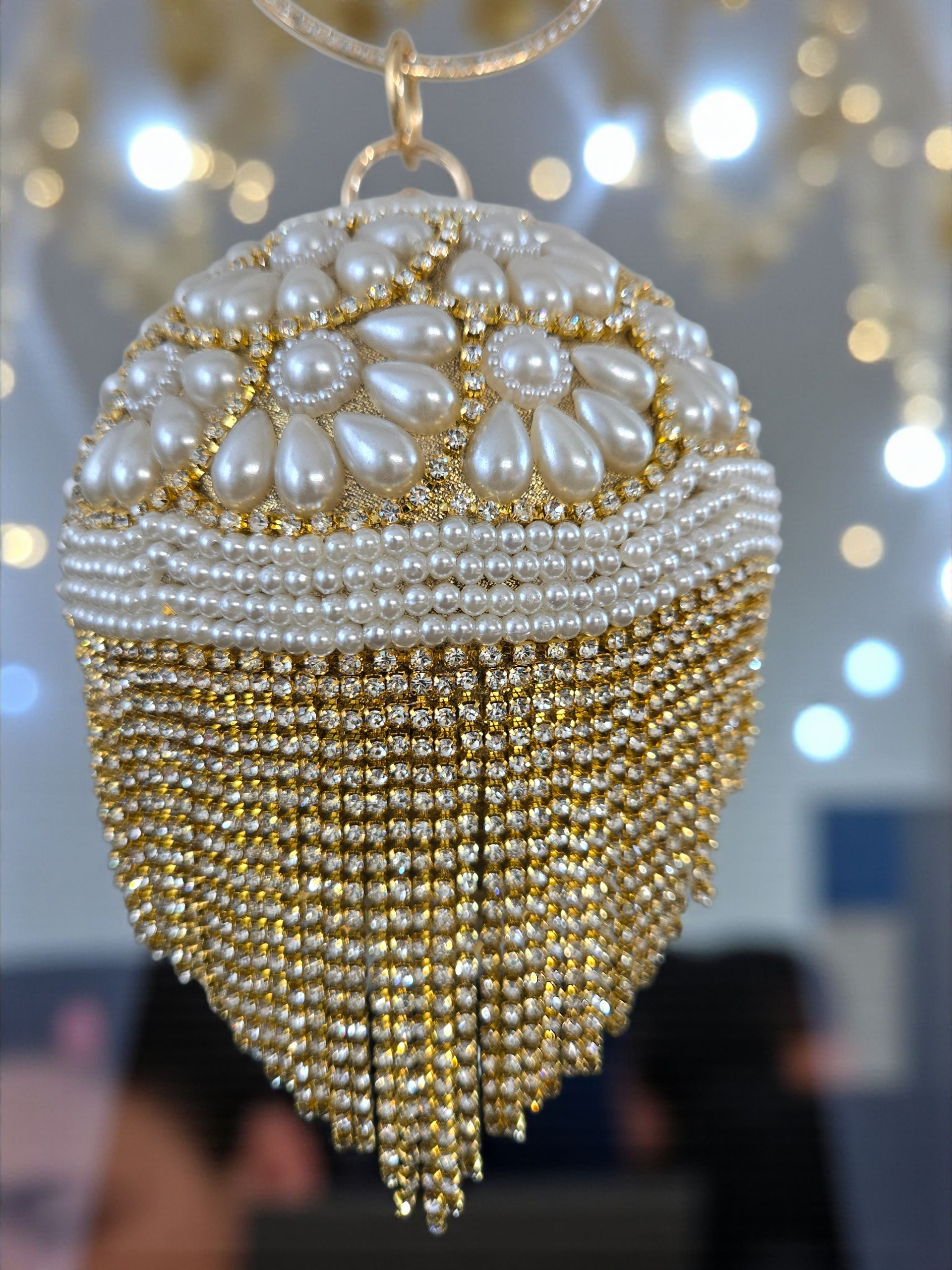 Bolso de mano de lujo para novia con flecos dorados y perlas florales.