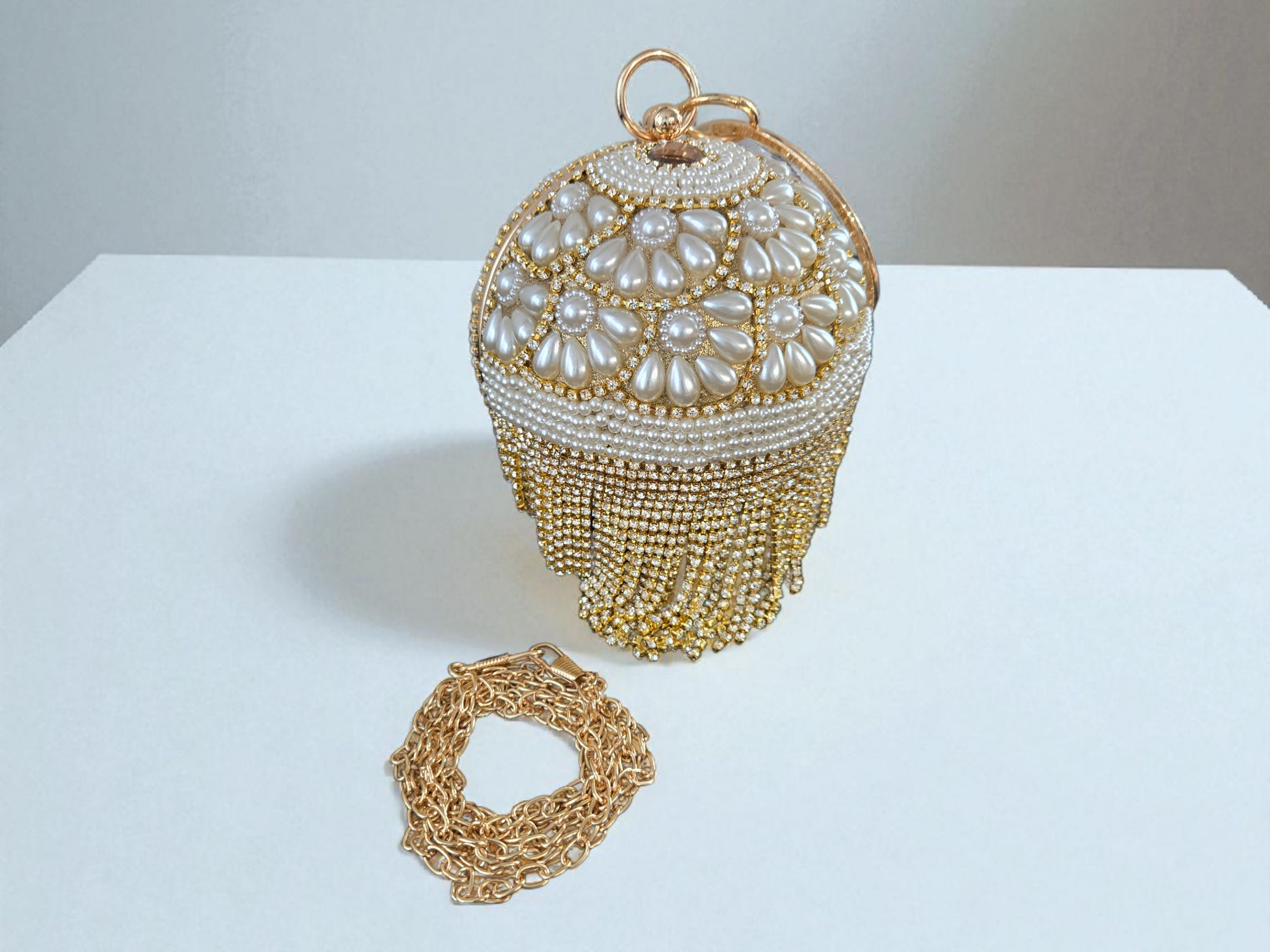 Bolso de mano de lujo para novia con flecos dorados y perlas florales.